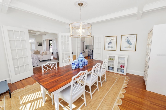 dining room with hardwood / wood-style flooring, a notable chandelier, french doors, and beamed ceiling