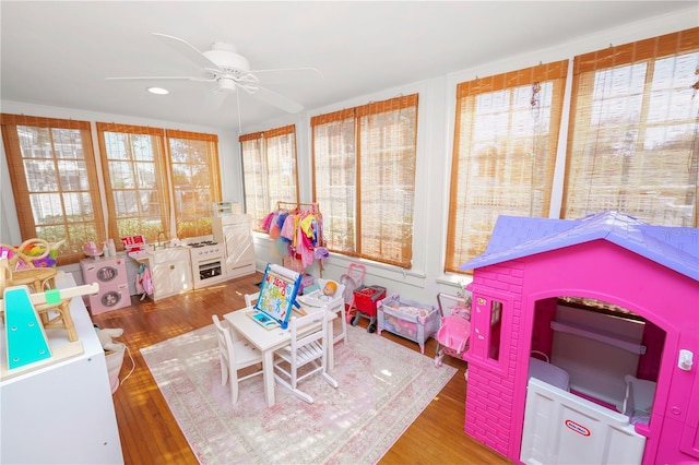 rec room with hardwood / wood-style floors and ceiling fan