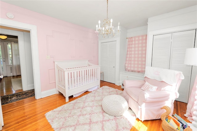 bedroom with an inviting chandelier and hardwood / wood-style flooring