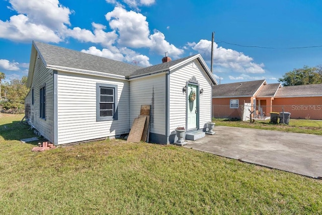 back of house featuring a patio and a lawn