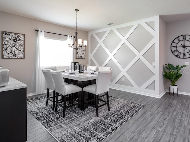 dining area featuring dark wood-type flooring and a chandelier