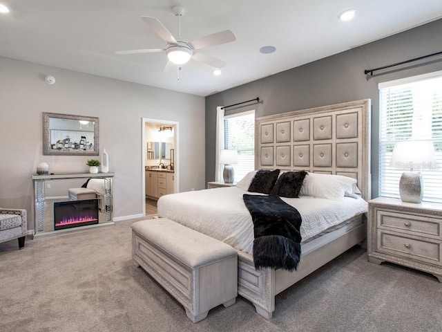 carpeted bedroom with ensuite bathroom and ceiling fan