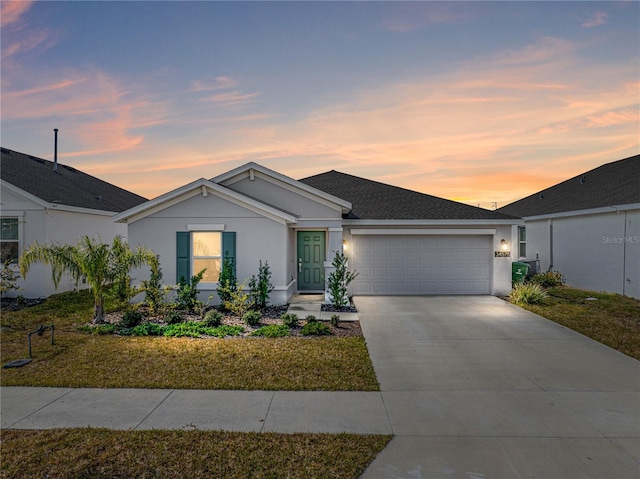 single story home with a garage and a lawn