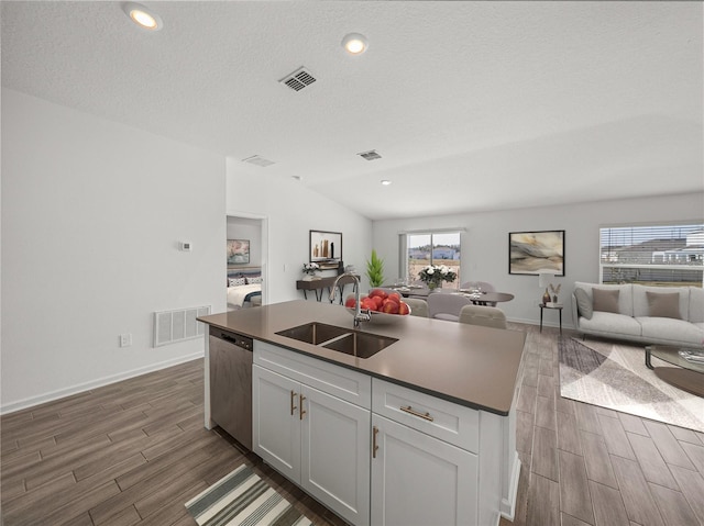 kitchen with sink, vaulted ceiling, a center island with sink, dishwasher, and white cabinets