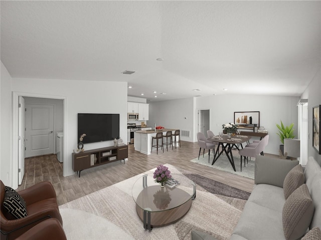 living room featuring vaulted ceiling and light wood-type flooring