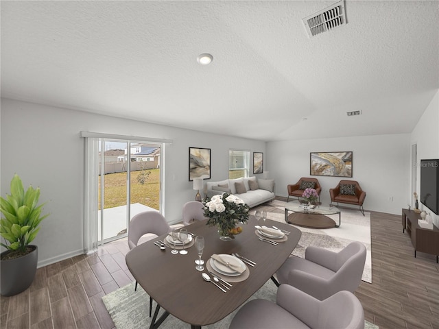 dining room featuring a wealth of natural light, dark hardwood / wood-style floors, and a textured ceiling