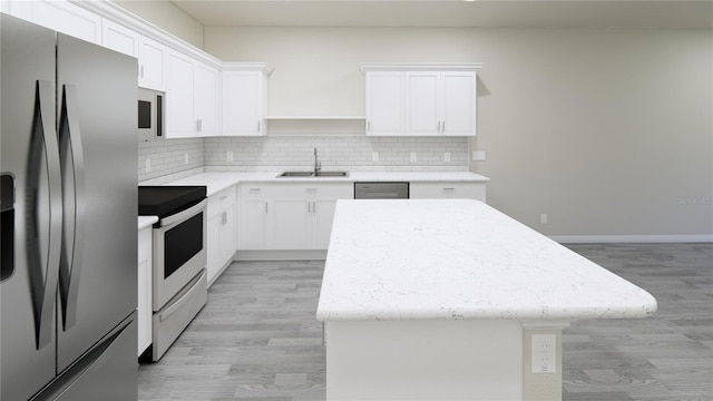 kitchen featuring sink, backsplash, stainless steel appliances, a center island, and white cabinets