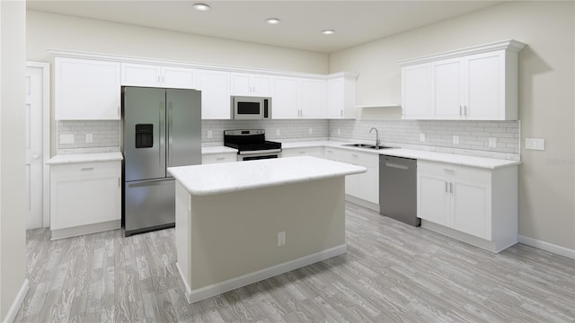 kitchen with white cabinetry, stainless steel appliances, sink, and decorative backsplash