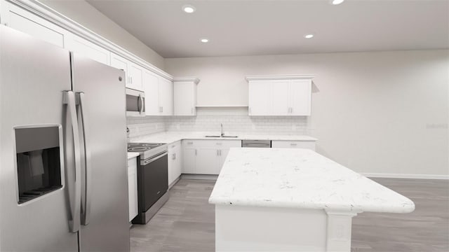 kitchen featuring white cabinetry, stainless steel appliances, sink, and a kitchen island