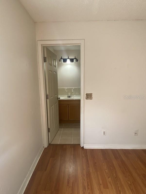 corridor featuring wood-type flooring and a textured ceiling