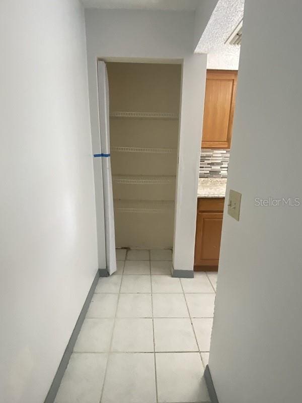 hallway featuring light tile patterned flooring