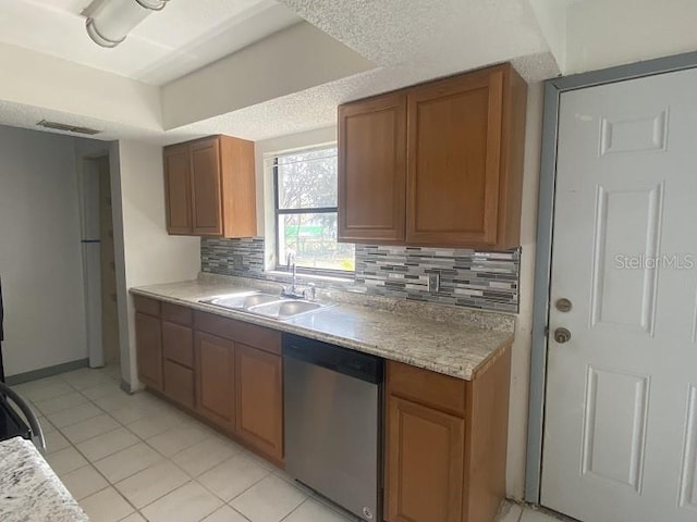 kitchen featuring tasteful backsplash, dishwasher, sink, and light tile patterned floors