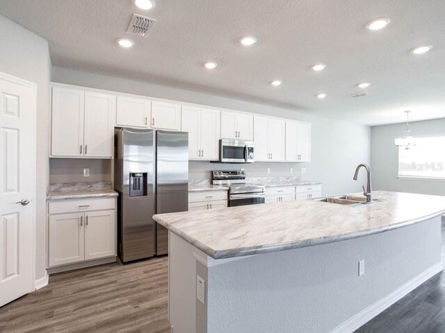 kitchen featuring sink, a center island with sink, white cabinets, and appliances with stainless steel finishes