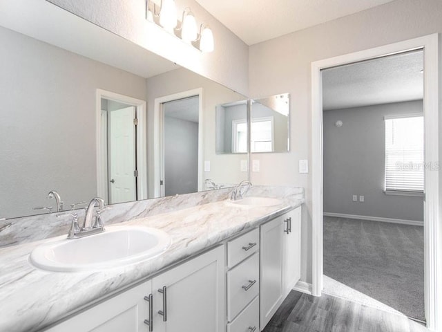 bathroom with vanity, wood-type flooring, and a textured ceiling