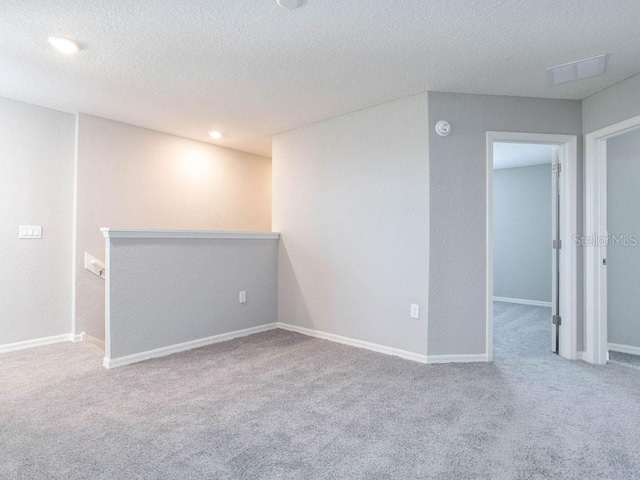 carpeted spare room featuring a textured ceiling