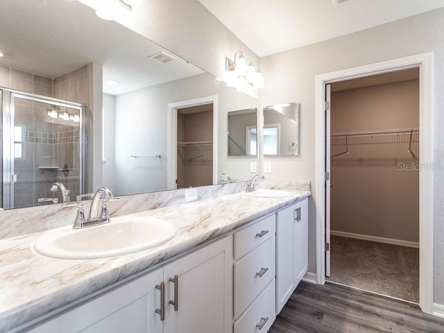 bathroom featuring vanity, wood-type flooring, and walk in shower