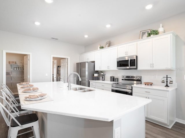 kitchen featuring white cabinetry, appliances with stainless steel finishes, and an island with sink