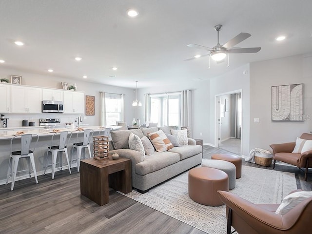 living room with dark wood-type flooring and ceiling fan