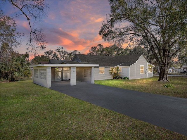 ranch-style house with a yard and a carport