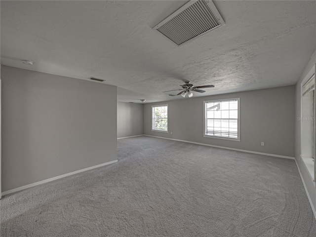 empty room featuring ceiling fan, carpet, and a textured ceiling