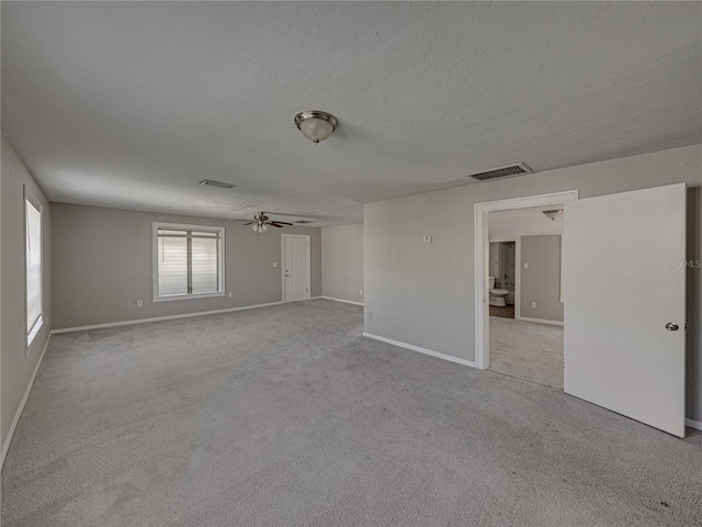 carpeted spare room with ceiling fan and a textured ceiling