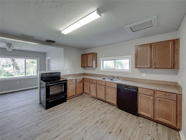 kitchen with sink, black appliances, light hardwood / wood-style floors, and a healthy amount of sunlight