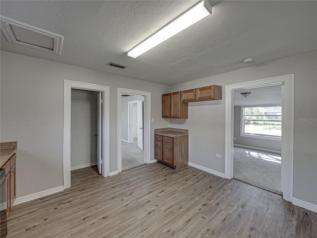 kitchen with light hardwood / wood-style flooring and a textured ceiling