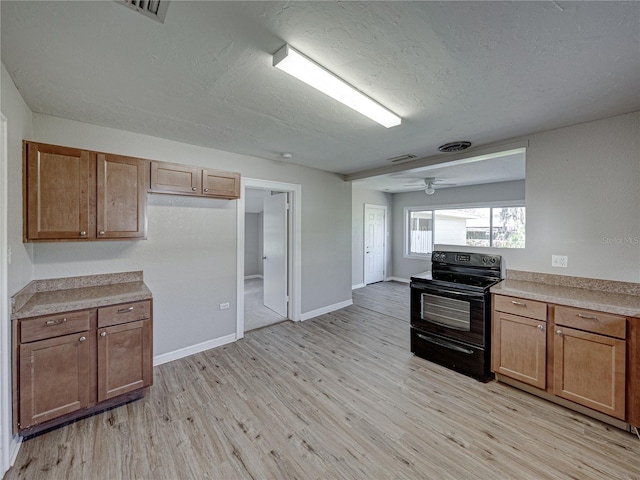 kitchen featuring ceiling fan, black range with electric stovetop, a textured ceiling, and light wood-type flooring