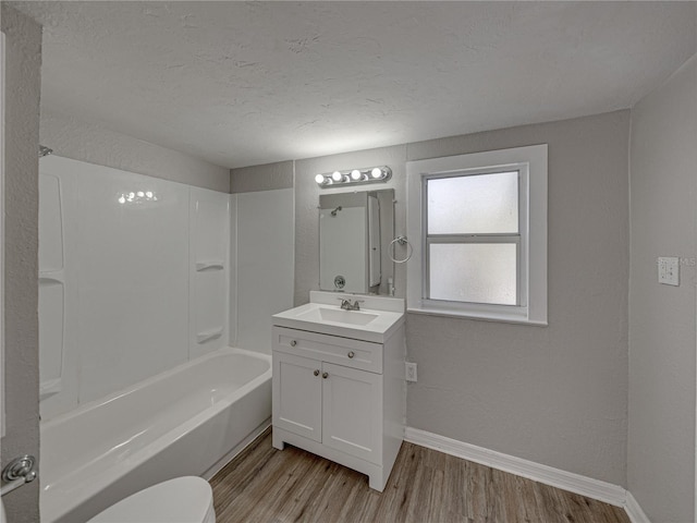 full bathroom featuring hardwood / wood-style flooring, vanity, a textured ceiling, and shower / tub combination