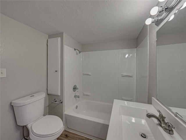 full bathroom featuring sink, hardwood / wood-style flooring, shower / bath combination, a textured ceiling, and toilet