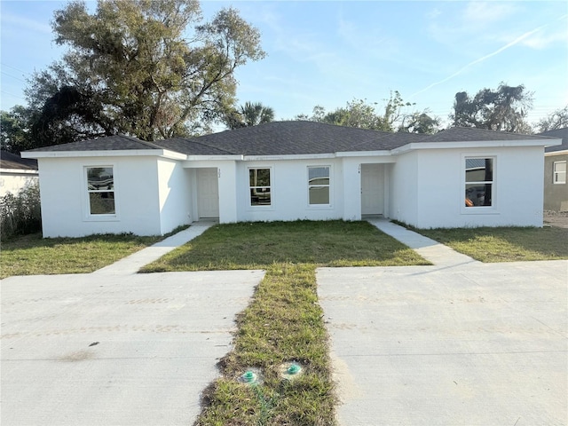 ranch-style home with a front lawn and stucco siding