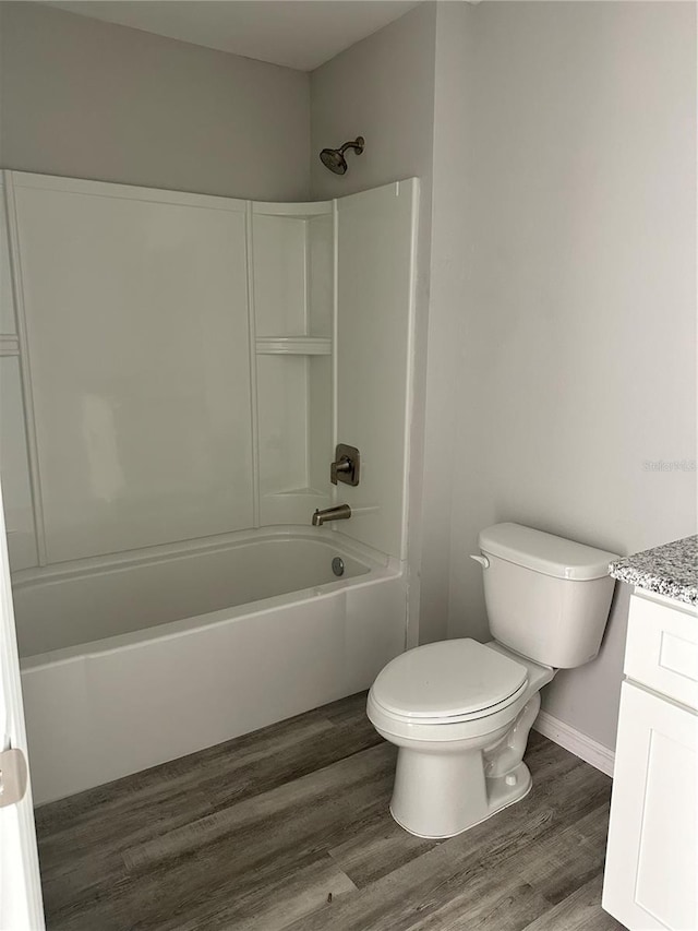 full bathroom featuring vanity, hardwood / wood-style floors, toilet, and washtub / shower combination