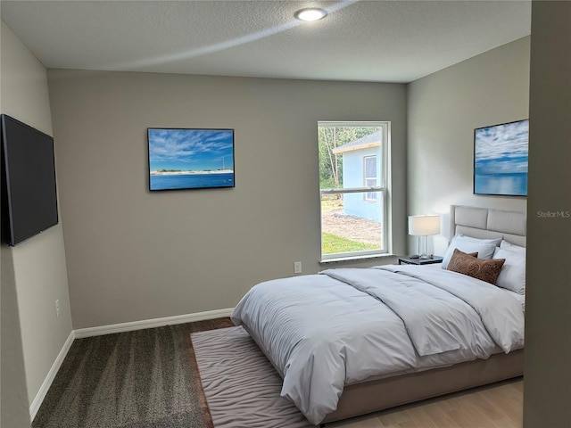 bedroom featuring baseboards and a textured ceiling