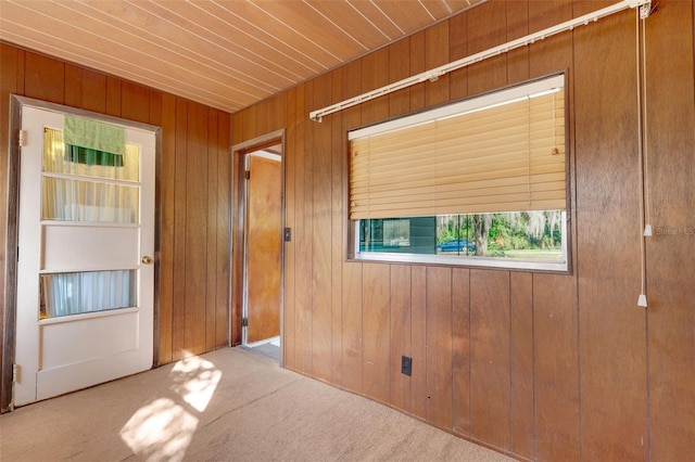 carpeted empty room with wooden walls and wooden ceiling