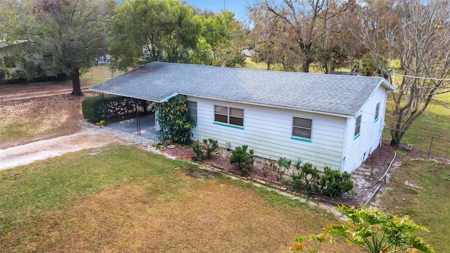 view of front of property with a carport and a front lawn