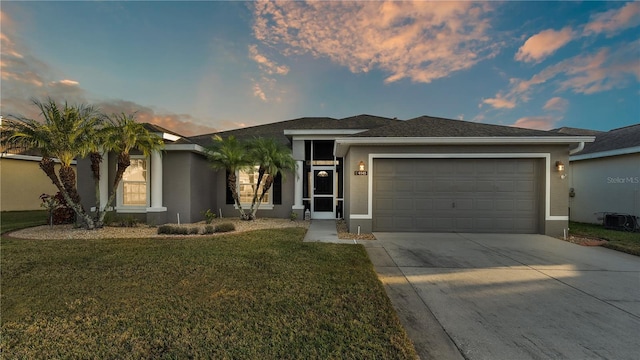 view of front of home featuring a garage and a lawn