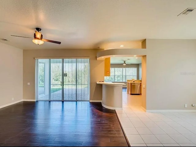 unfurnished living room with wood-type flooring, a textured ceiling, and ceiling fan