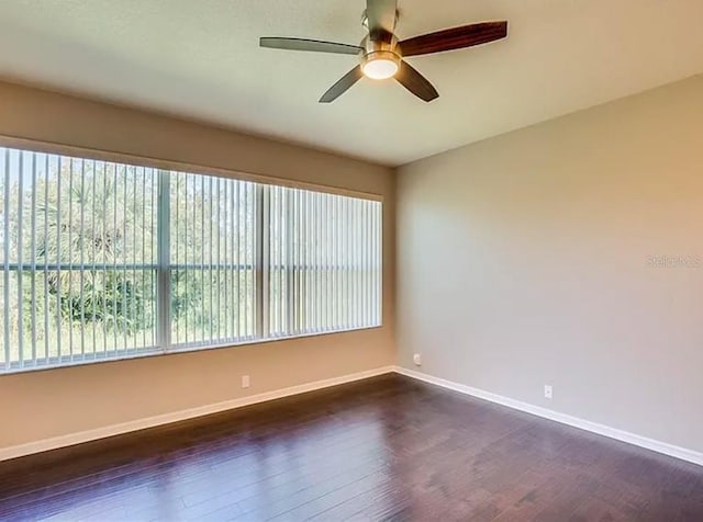 unfurnished room featuring plenty of natural light, dark wood-type flooring, and ceiling fan