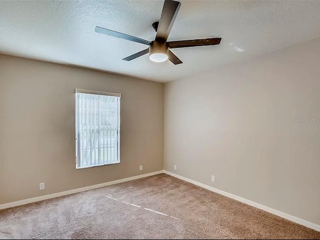 carpeted spare room with ceiling fan and a textured ceiling