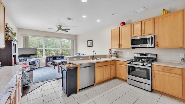 kitchen with visible vents, light brown cabinetry, stainless steel appliances, a peninsula, and light countertops