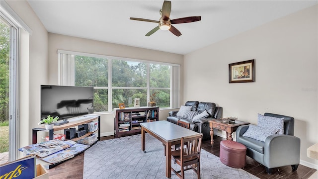 living room featuring baseboards, wood finished floors, and a ceiling fan