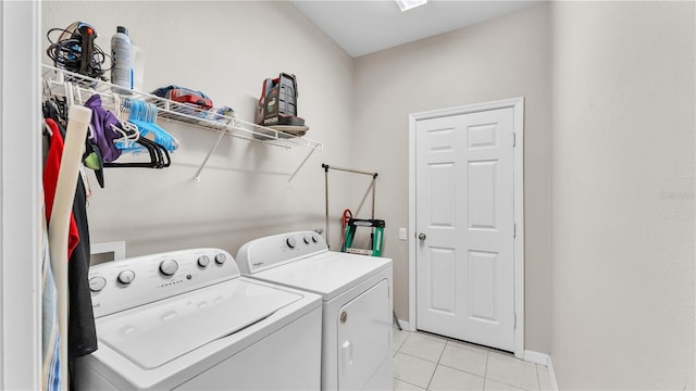 washroom with laundry area, light tile patterned floors, baseboards, and independent washer and dryer