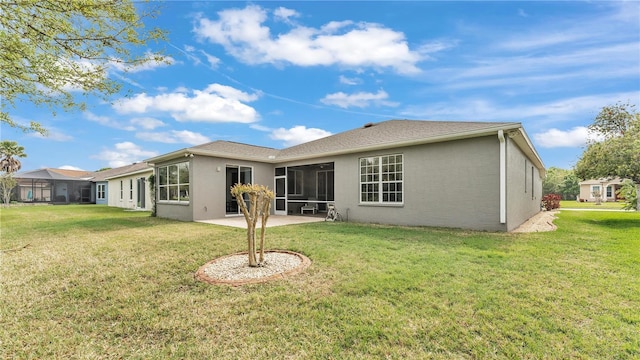 rear view of property with a yard, a sunroom, and a patio area