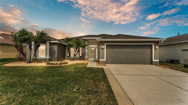 ranch-style home featuring stucco siding, driveway, an attached garage, and a front yard