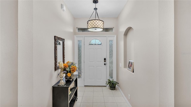 foyer with light tile patterned floors, baseboards, and arched walkways