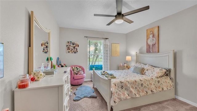 bedroom featuring light colored carpet, a ceiling fan, and baseboards