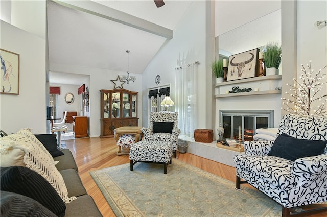 living room featuring beamed ceiling, a large fireplace, high vaulted ceiling, and hardwood / wood-style floors