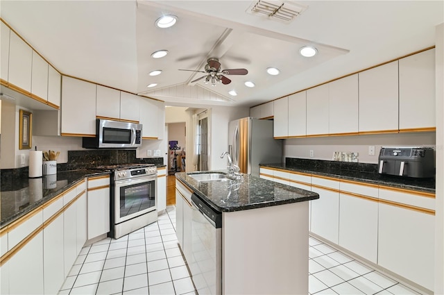 kitchen with sink, white cabinetry, light tile patterned floors, appliances with stainless steel finishes, and an island with sink