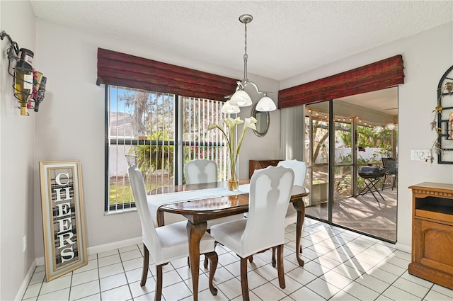 dining space featuring a textured ceiling and light tile patterned floors