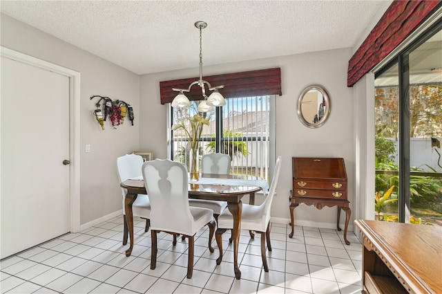 tiled dining room with a notable chandelier and a textured ceiling